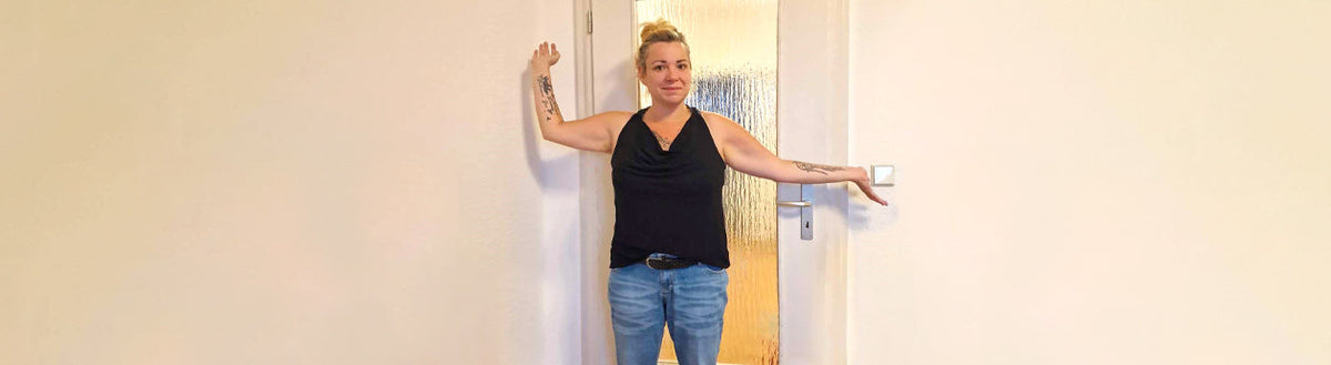 Katja (36) nach ihrer Gewichtsabnahme mit Precon, lächelnd im Türrahmen stehend