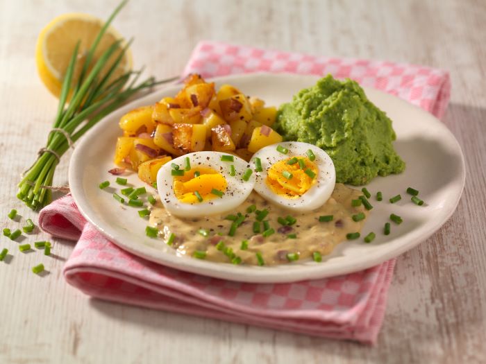 Gekochte Eier in Senfsauce mit Bratkartoffeln und Erbsenpüree